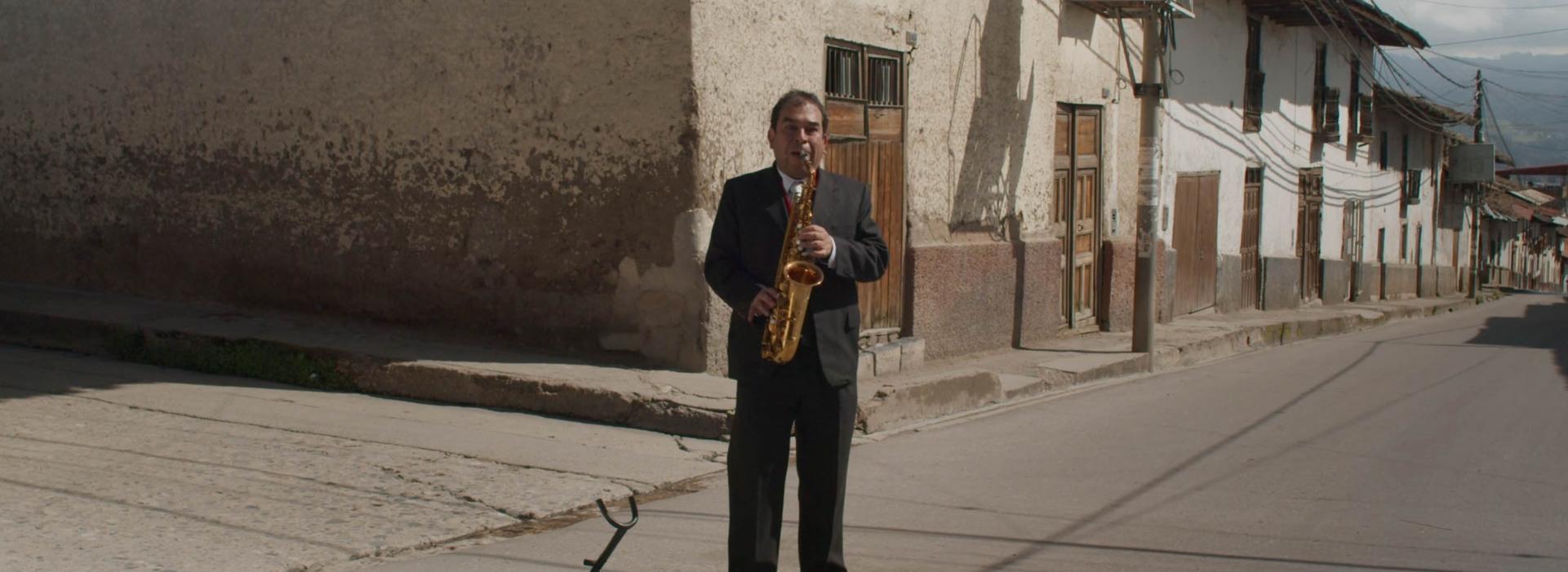Un hombre toca el saxofón en la calle.