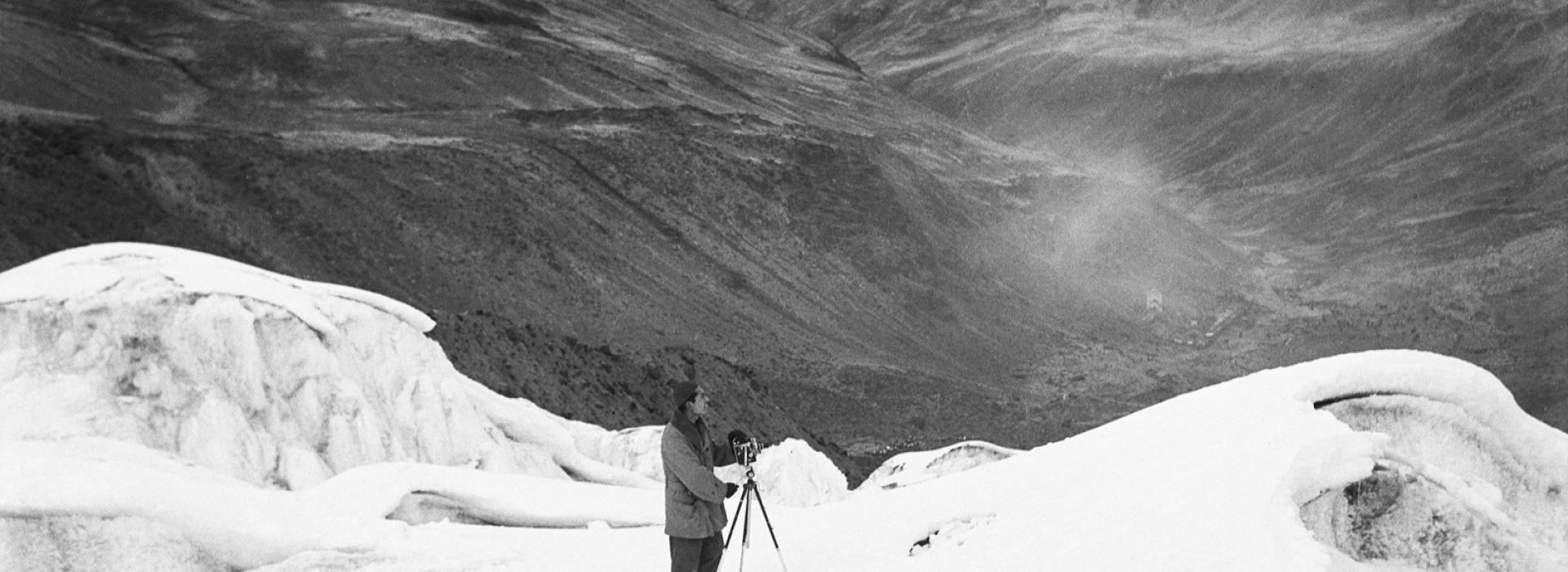 Un hombre fotografía las montañas nevadas.