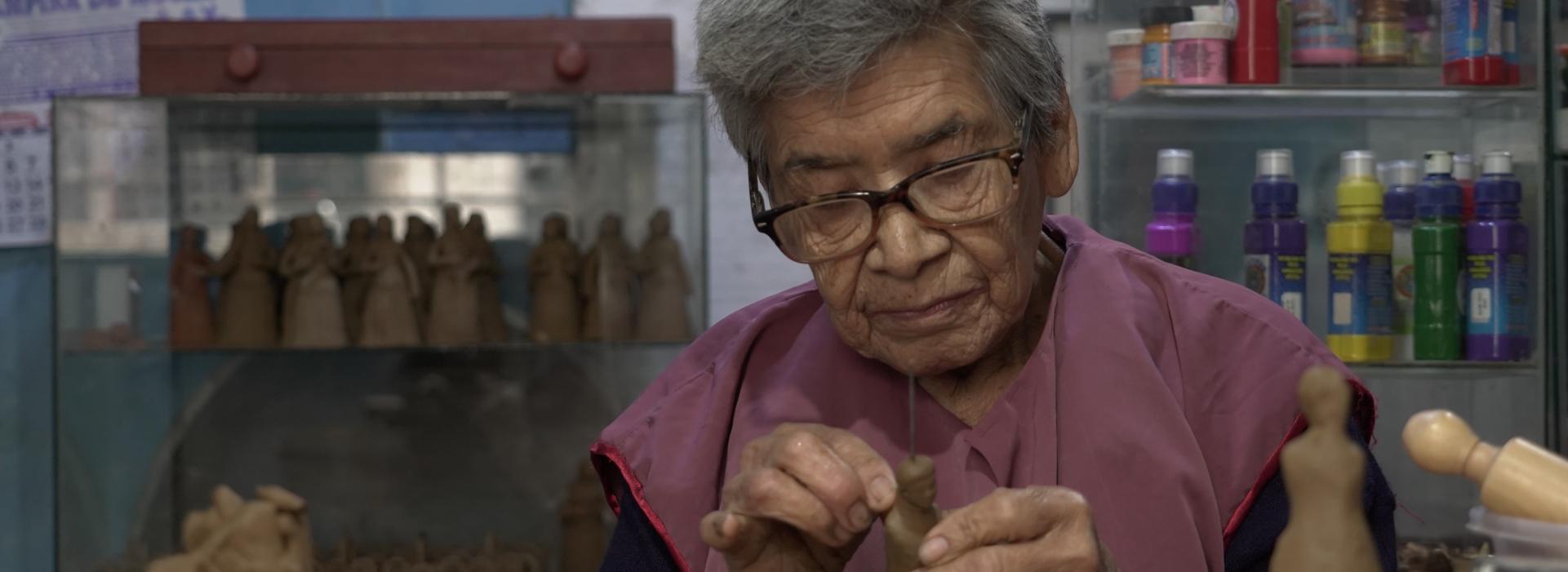 Una artesana forma figuritas en su taller.