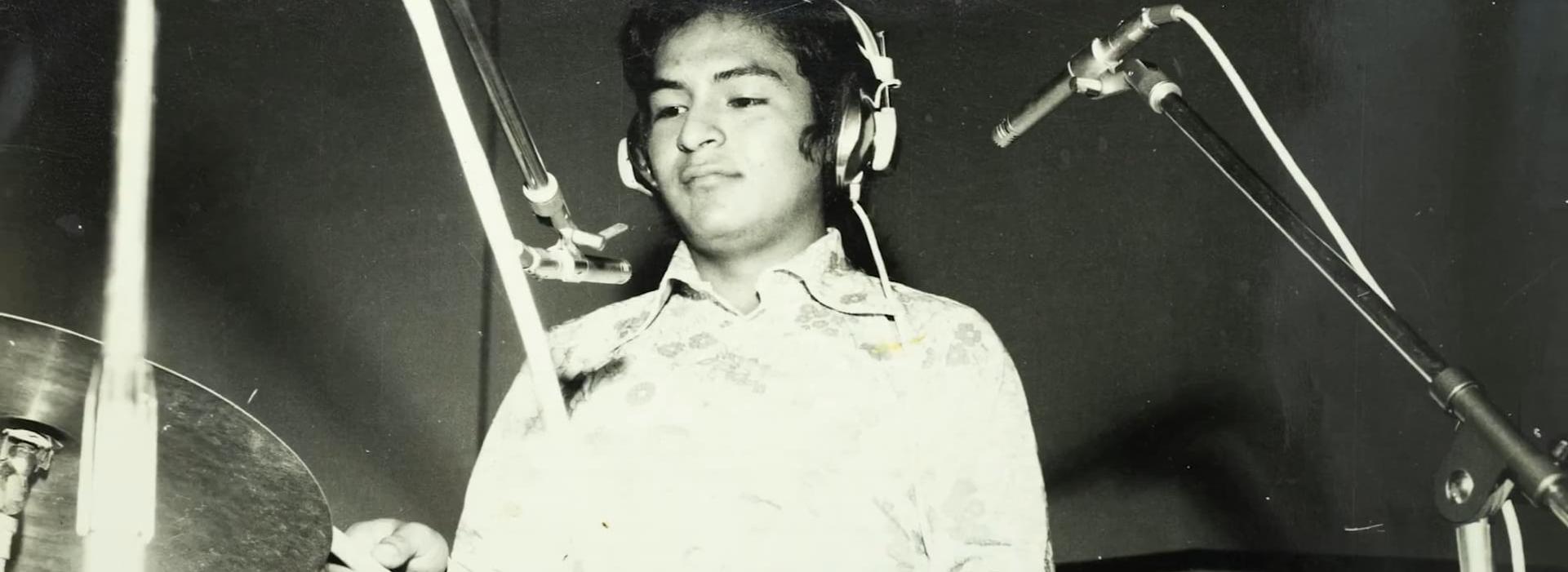 Un joven toca la batería. Imagen vista desde abajo y en blanco y negro.