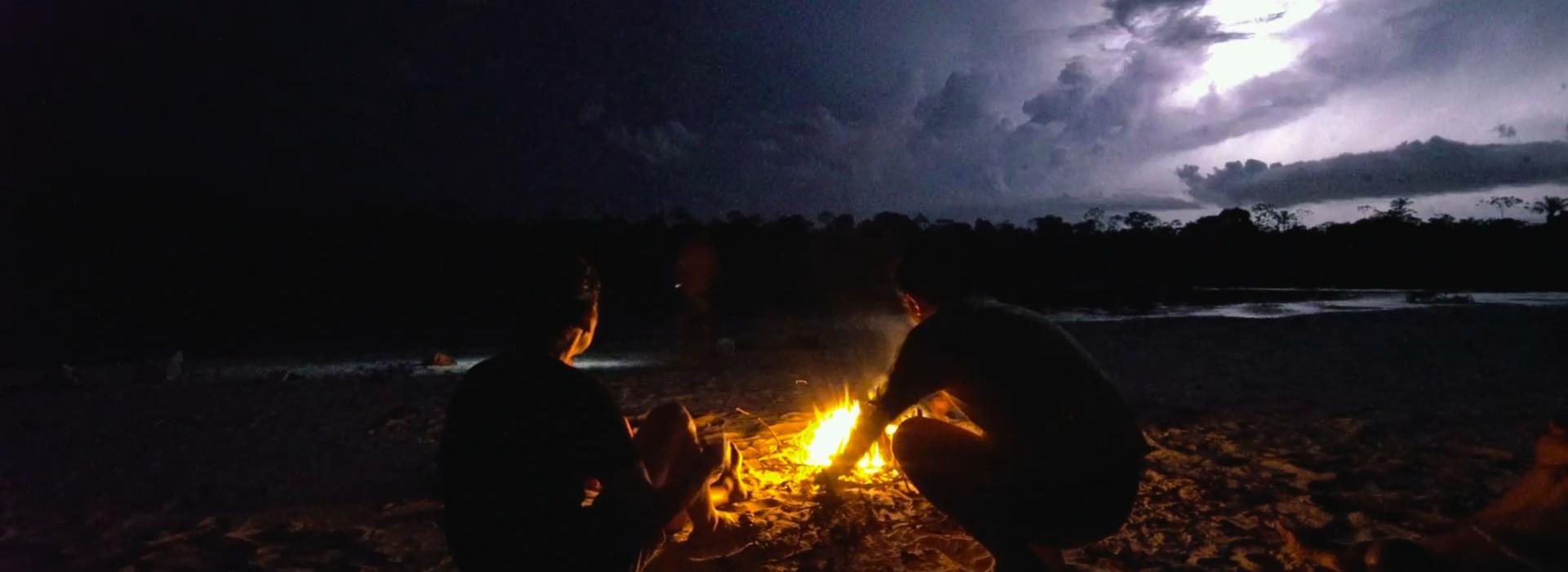 Fotograma de Ruta Madre, atardecer con una fogata