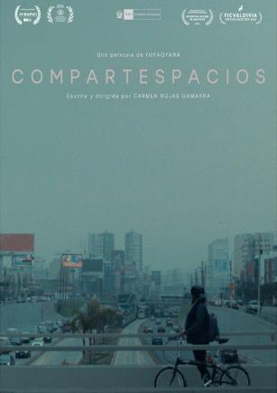 Una ciudad oscura con una persona en bicicleta en primer plano.