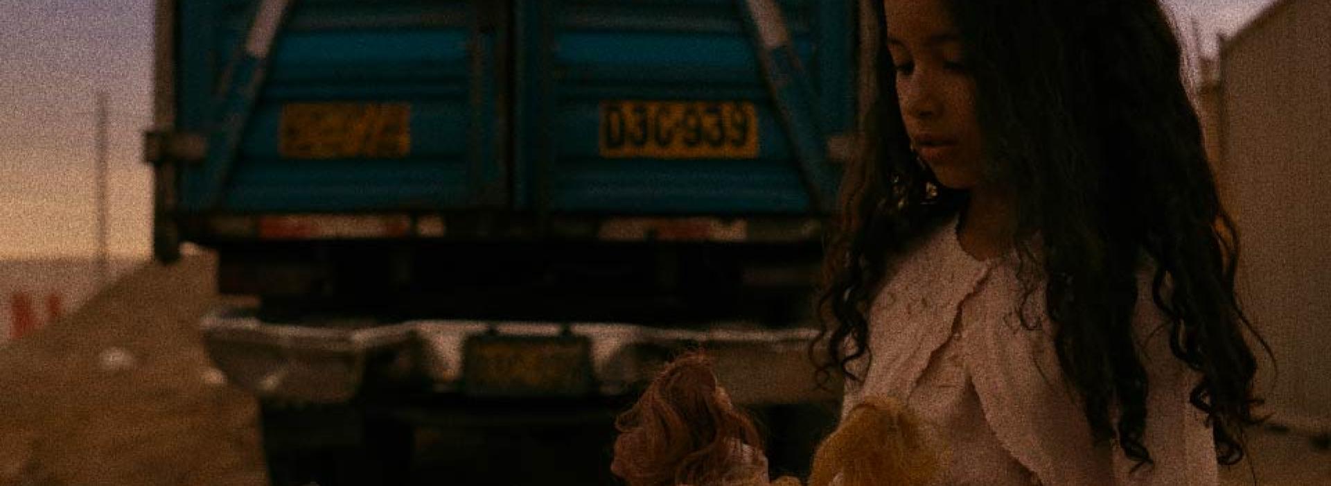 Una niña juega con muñecas.