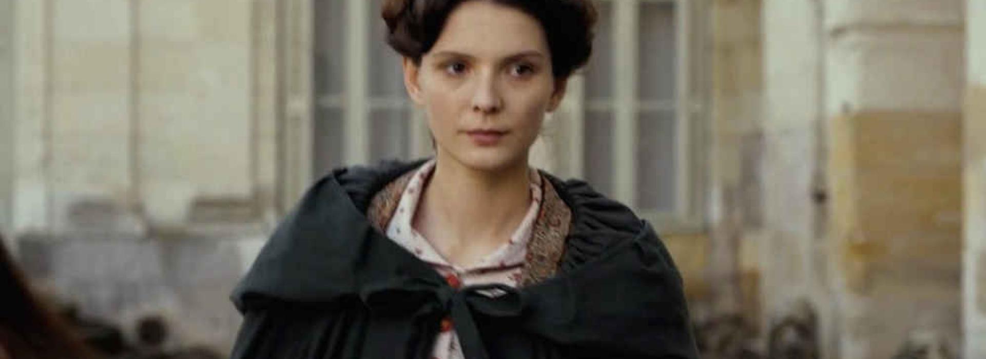 Una mujer vestida con ropa de luto camina.